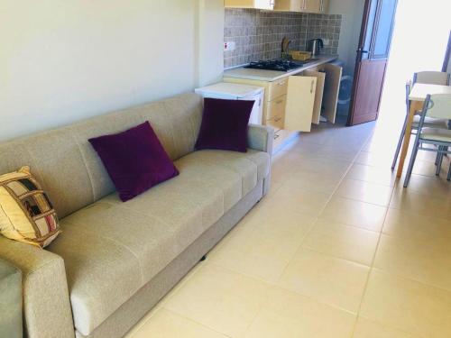 a living room with a couch and a kitchen at SEA & SKY Bungalows Escape Beach Guest Rooms in Kérynia