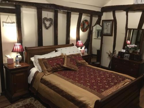 a bedroom with a bed and two lamps and two tables at Ivy Todd cottage in Debden