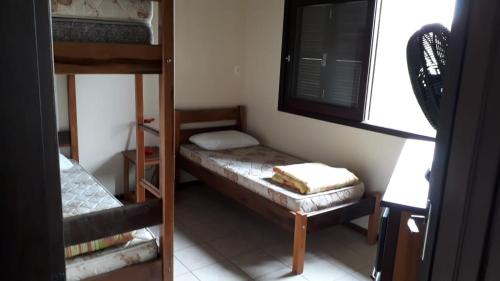 a room with two bunk beds and a window at Garopaba casa 8 Morrinhos in Garopaba