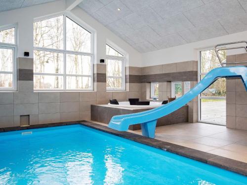 a indoor swimming pool with a slide in a house at 14 person holiday home in Str by in Strøby