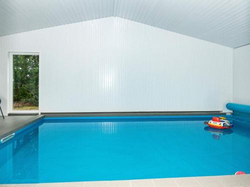 a swimming pool with a red toy boat in a room at 8 person holiday home in R m in Bolilmark