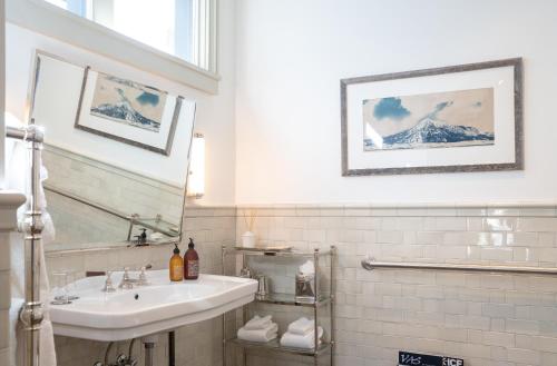 a white bathroom with a sink and a mirror at Public House Lofts in Crested Butte