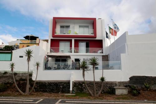 a large building with a large window on top of it at Garoupas Inn in Ponta Delgada