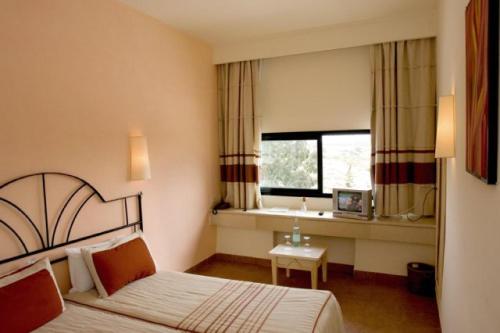 ein Hotelzimmer mit einem Bett und einem Fenster in der Unterkunft Sufetula Hotel in Sbeitla