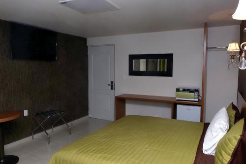 a bedroom with a bed and a desk in it at Royal Madero Inn in Ciudad Madero