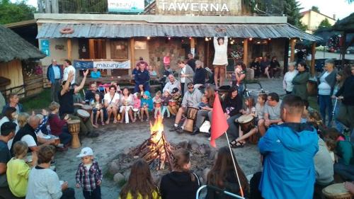 a group of people sitting around a fire at Przystań Tło dla Mew in Rydzewo