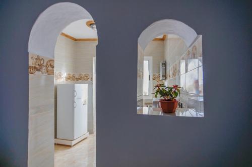a hallway with arches and a refrigerator in a room at Dar Sidi Mfedal in Chefchaouene