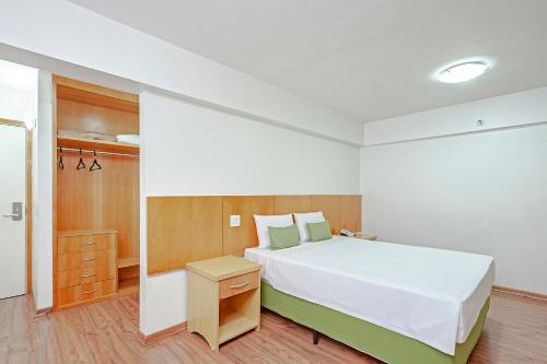 a bedroom with a large white bed and a closet at Slim São Paulo Congonhas in Sao Paulo