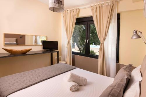 a bedroom with a bed and a window at Entechnos Living in Skiathos Town