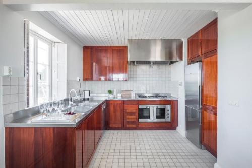 a large kitchen with wooden cabinets and a sink at Sands Hotell in Sandhamn