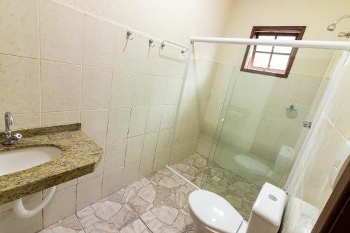 y baño con ducha, aseo y lavamanos. en Namoa Pollastrini, en Itanhaém