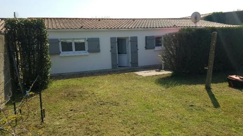 une petite maison blanche avec une clôture et une cour dans l'établissement MAISON VENDEENNE PROCHE DE L OCEAN, à Saint-Jean-de-Monts