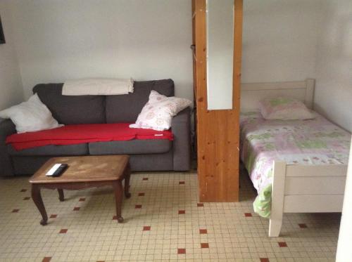 un salon avec un canapé et un lit dans l'établissement MAISON VENDEENNE PROCHE DE L OCEAN, à Saint-Jean-de-Monts
