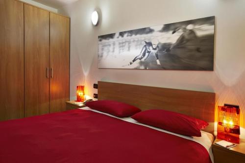 1 dormitorio con 1 cama roja y 2 almohadas rojas en Teleo Vacanze - Villaggio Olimpico di Sestriere, en Sestriere