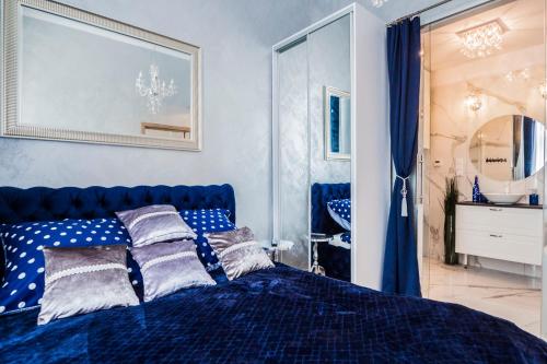 a blue bed with pillows on it in a bedroom at El Dorado Apartment z Jacuzzi in Wrocław