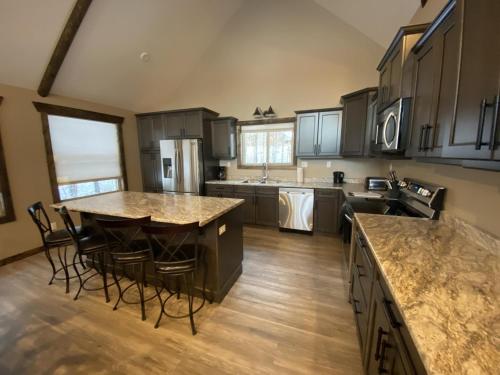 a large kitchen with wooden floors and a large island at Timber Lodge in Valemount