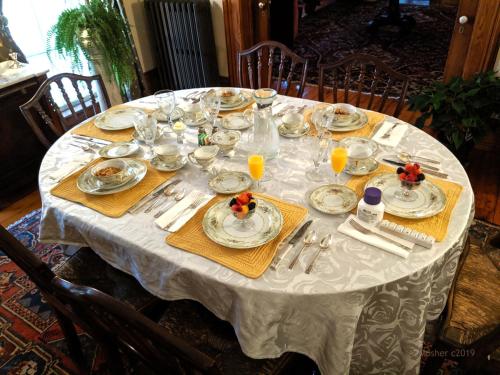 a white table with plates and glasses on it at Oakcliff Bed and Breakfast in Halfmoon