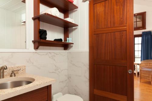 baño con lavabo y puerta de madera en Kahari Resort, a Peace and Plenty Resort Property, en Georgetown