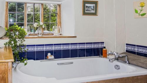 a white bath tub in a bathroom with blue tiles at The Harbour in Evenjobb