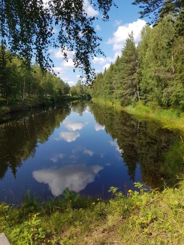 a river with a reflection of the sky in the water at Voxnabruks Kanot & Camping in Voxnabruk