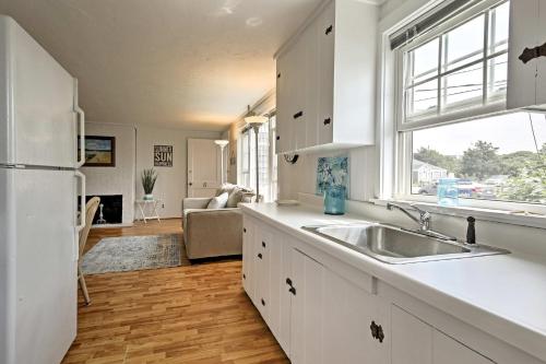 uma cozinha com armários brancos, um lavatório e uma janela em Updated Cottage - 300 Feet to Craigville Beach! em Centerville