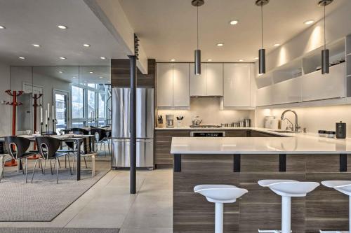 ベールにあるVail Condo with Mtn View Deck - Steps to Ski Shuttleの白いキャビネット、テーブル、椅子付きのキッチン