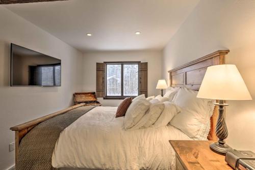 ベールにあるVail Condo with Mtn View Deck - Steps to Ski Shuttleの大きな白いベッドとランプのある寝室