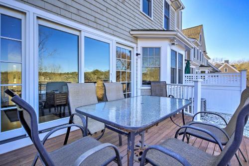 a patio with a table and chairs on a deck at 1 Mi to Town and Oyster Pond Beach Chatham Retreat in Chatham