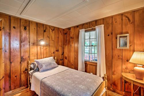 een slaapkamer met houten wanden en een bed met een raam bij Cape Cod House with Grill and Yard - Drive to Beach! in South Yarmouth