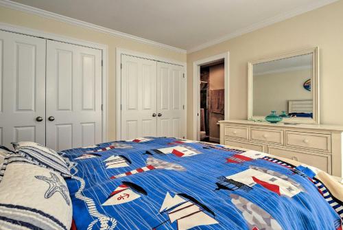 a bed with a blue comforter in a bedroom at 1 Mi to Town and Oyster Pond Beach Chatham Retreat in Chatham