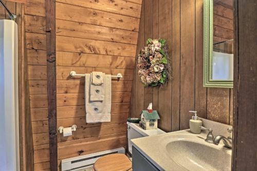 a bathroom with a sink and a wooden wall at Lakefront Berkshires Retreat with Deck, Dock and Boat! in Great Barrington