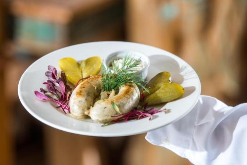 a person holding a white plate of food at Bartlowizna Serce Biebrzy noclegi in Goniadz