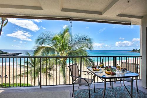 a table on a balcony with a view of the beach at Stunning Makaha Condo with Pool Access and Ocean View! in Waianae