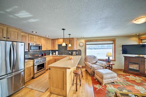 a kitchen with a stainless steel refrigerator and a chair at Lake Pend Oreille Condo with Porch and Mountain View! in Sandpoint