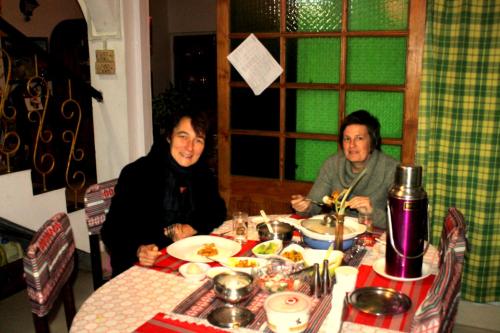 two women sitting at a table eating food at Mansarover Home Stay in Kalimpong