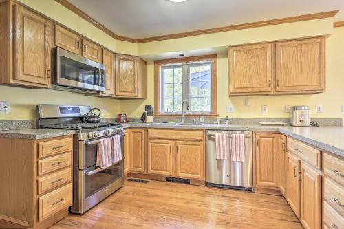 a kitchen with wooden cabinets and stainless steel appliances at Walk to Beach on Buzzards Bay Onset Home with Deck! in Onset