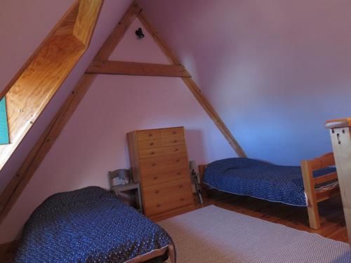 um quarto no sótão com 2 camas e uma escada em La Chaumière d'Alambre em Moudeyres