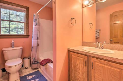 a bathroom with a toilet and a sink and a window at Walk to Beach on Buzzards Bay Onset Home with Deck! in Onset