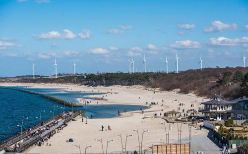 a beach with people on the sand and the water at Apartament Morski przy plazy in Darłówko