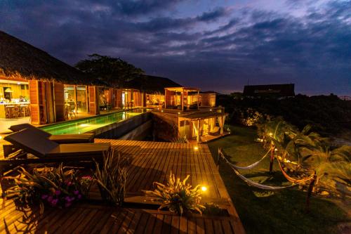 a villa with a swimming pool at night at Casa Safran Vichayito in Los Órganos