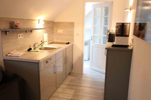 a small kitchen with a sink and a microwave at Haus Eichenhain FeWo Hamburg in Scheeßel