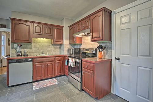 a kitchen with wooden cabinets and a white appliance at Beautiful Lenox Home, 3 Mi to Shakespeare and Co! in Lenox