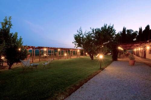 a yard with chairs and lights at night at Agriturismo Valle Siriaca in Castelnuovo di Porto