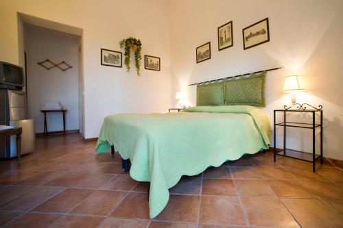 a bedroom with a bed with a green blanket at Agriturismo Valle Siriaca in Castelnuovo di Porto