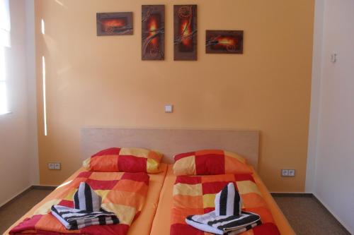 um quarto com 2 camas e cobertores coloridos em Pension Am Steinberg em Muldenstein
