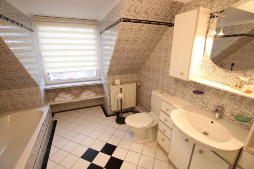 La salle de bains est pourvue d'un lavabo, de toilettes et d'une baignoire. dans l'établissement Ferienwohnung Heide, à Scheeßel