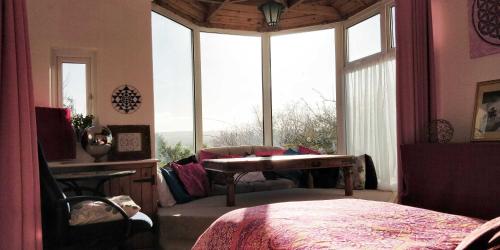 una camera da letto con tavolo, divano e finestra di Stargaia Retreat a Glastonbury