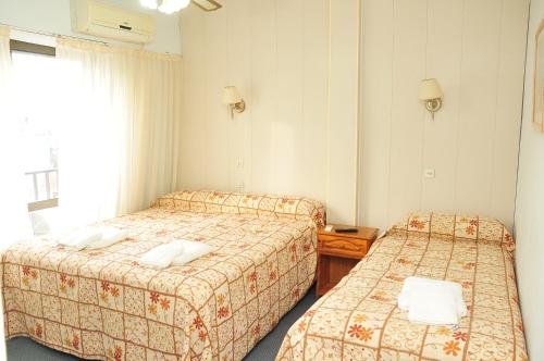 ein Hotelzimmer mit zwei Betten und einem Fenster in der Unterkunft Hotel Frasi's in San Clemente del Tuyú