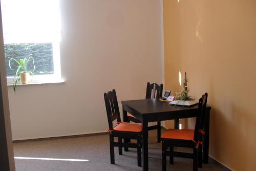 mesa de comedor con 4 sillas y ventana en Pension Am Steinberg, en Muldenstein