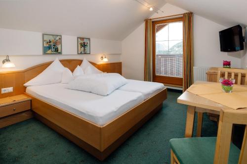 a hotel room with a bed and a table at Haus Anemone in Serfaus